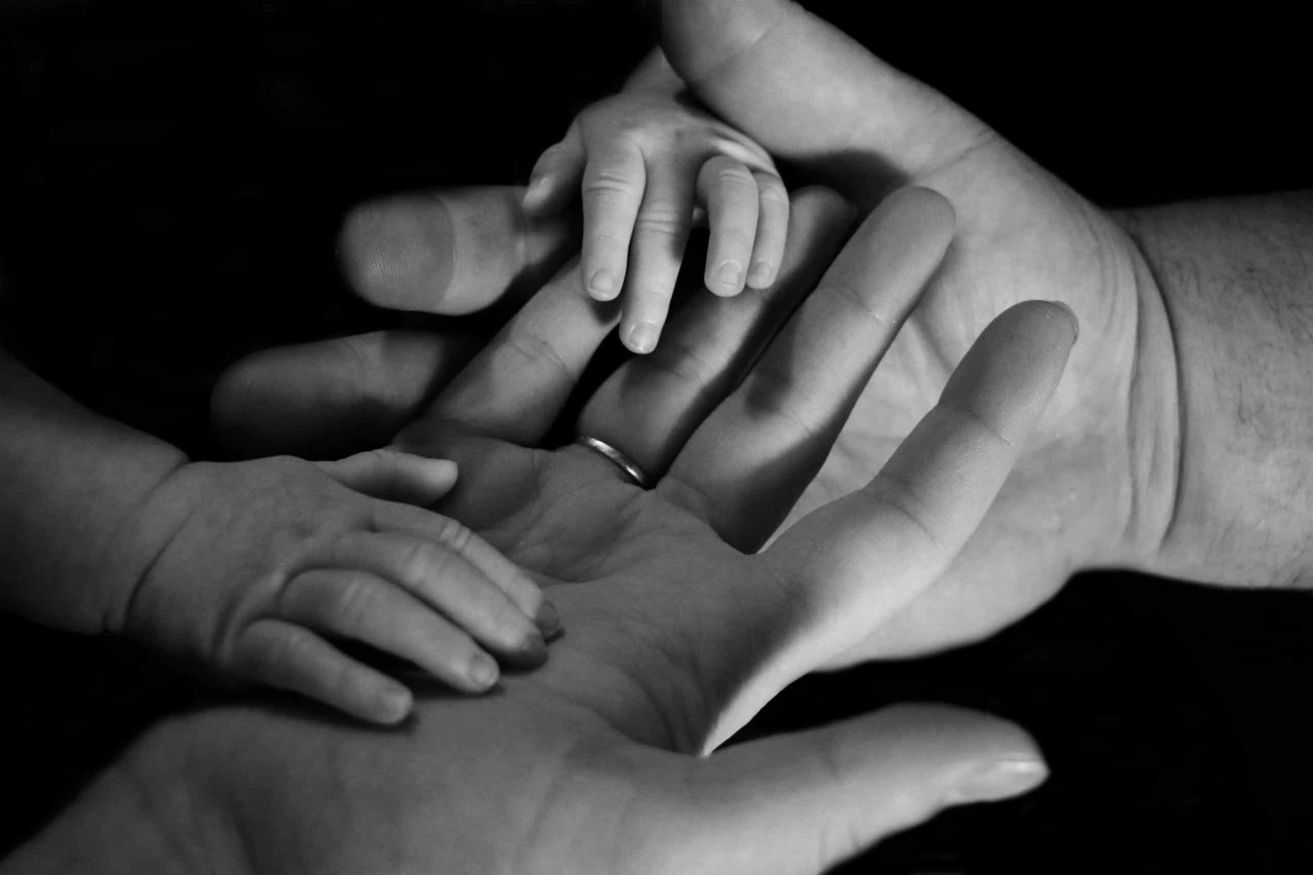 FAMILY LEGAL ADVICE - parents holding baby's hand